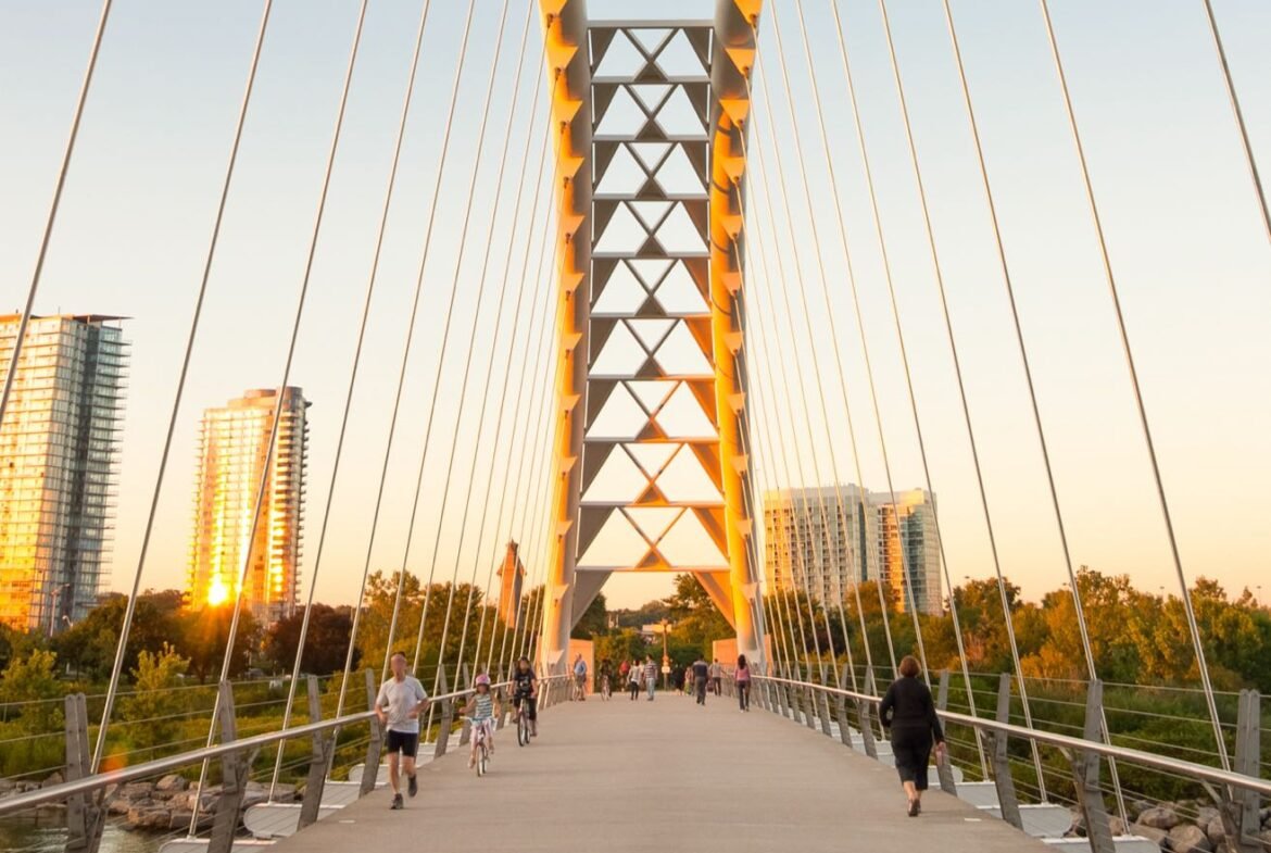 A new bridge over a river with people walking on it.