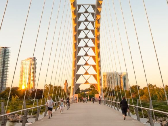 A new bridge over a river with people walking on it.