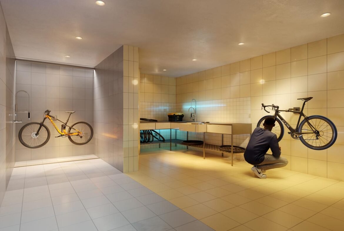 A man is kneeling in front of a new bike in a bathroom.