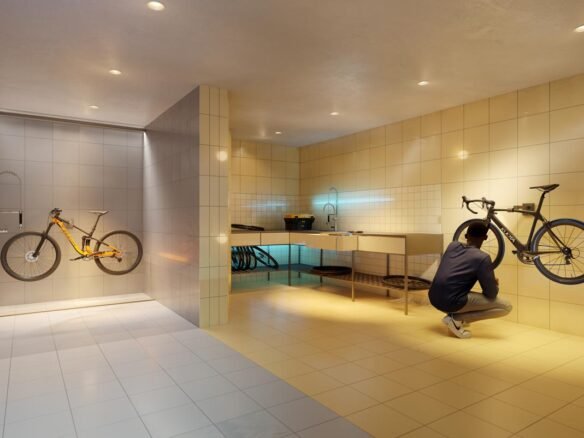A man is kneeling in front of a new bike in a bathroom.