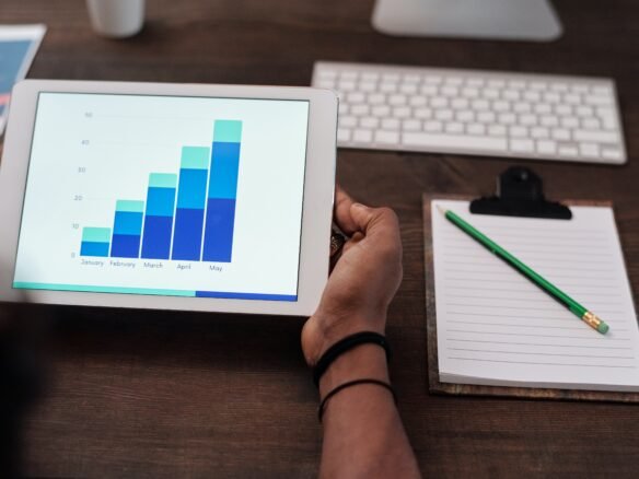 A person holding a tablet with a graph on it, showcasing information about new homes in pre construction.