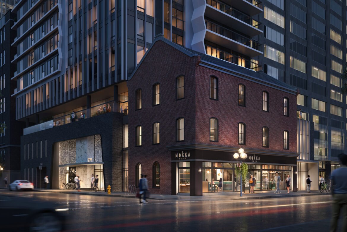 A nighttime city street scene showcases a modern building with a historic brick facade on the corner. The structure, under the glow of illuminated signage, attracts people walking along the wet sidewalk. Nearby modern skyscrapers surround the area, reminiscent of new condos in Brampton.