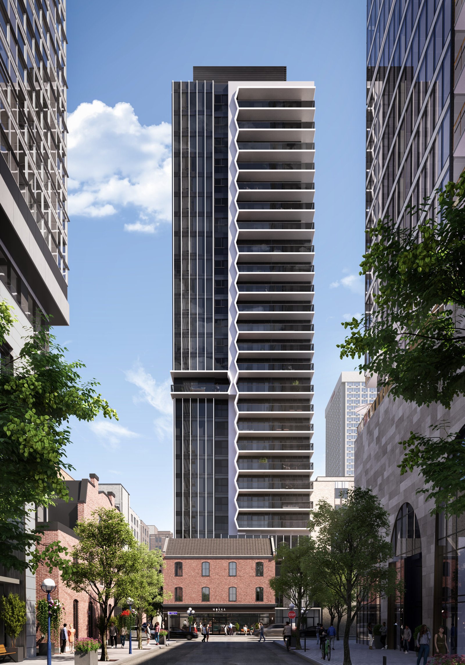 A contemporary high-rise with a distinctive zigzag pattern of balconies stands against a clear blue sky in Brampton. Lined with trees, the street below features a historic brick building and a few pedestrians, offering an inviting contrast to the new condos that redefine modern living.