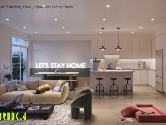 A modern, cozy living space at Brooklin Towns featuring a kitchen, family room, and dining area. A tan sectional sofa with a dog resting on it faces a coffee table and a neon "LET'S STAY HOME" sign. The kitchen has sleek white cabinets, pendant lights, and a breakfast bar with stools. A pet bed and toys are on the floor.