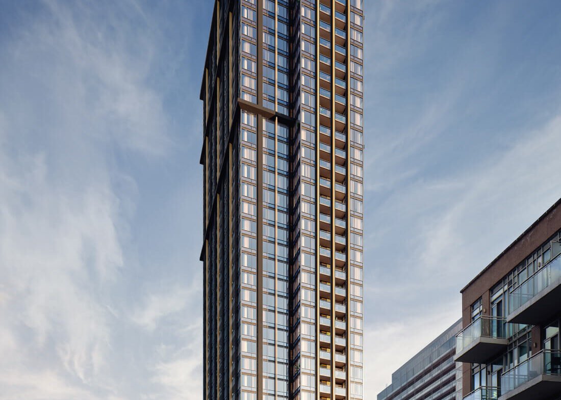 A towering modern skyscraper with sleek glass and steel architecture stands prominently under a partly cloudy sky. The building displays an elegant, grid-like facade with various reflections. Nearby, smaller buildings line the street, which has light traffic and several signs advertising new homes in GTA.