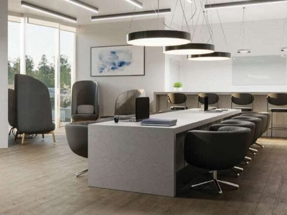Modern office space with a large, rectangular table surrounded by swivel chairs. Hanging circular lights illuminate the area. To the left, two pod-like chairs are positioned near full-length windows, and a bar-style counter with stools is at the back—a perfect setup for discussions about new homes in GTA.