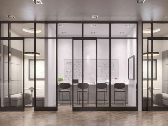 A modern conference room with glass walls inside one of the new condos in GTA. There's a long table with six black chairs, a whiteboard covered in sketches, two windows, and a circular ceiling light. There are two small seating areas with round tables and gray chairs on either side.