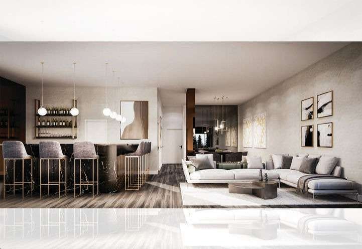 A modern open-concept living space in one of the new homes in GTA features a kitchen bar on the left with high stools and hanging lights. The right side has a cozy living area with a large sectional sofa, a coffee table, and wall art. The space is bright with a minimalist, elegant design.