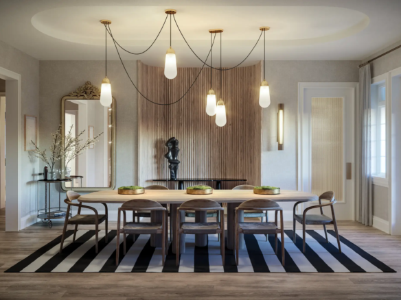 A modern dining room in one of the elegant new homes in GTA features a large wooden table with eight chairs, set on a black-and-white striped rug. Pendant lights hang from the ceiling, while the background showcases a wooden accent wall adorned with artwork and decorative items. Large windows provide ample natural light.