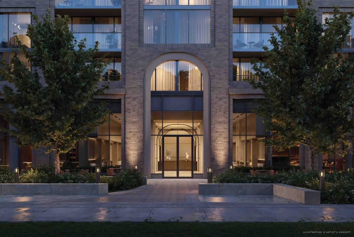 An elegant brick building with archways lit up at twilight, featuring illuminated interiors, tree-lined walkways and a serene atmosphere at Sg Homes.