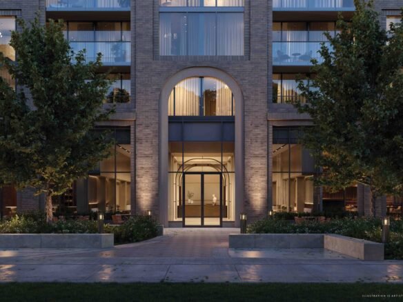 An elegant brick building with archways lit up at twilight, featuring illuminated interiors, tree-lined walkways and a serene atmosphere at Sg Homes.