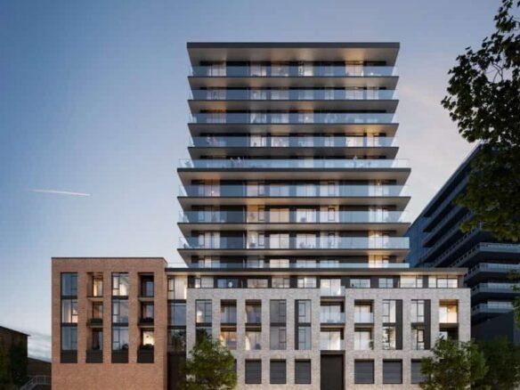 A modern mixed-use building features a sleek, reflective glass facade with multiple balconies on its upper floors. The lower floors have brick and stone exteriors. Trees line the sidewalk, and people are walking nearby at dusk, exploring the new condos in GTA available in this vibrant community.