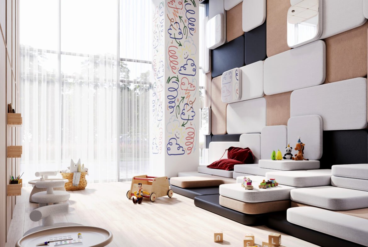 A modern LSQ 2 playroom with a high ceiling, featuring padded wall panels in various shades of beige, black, and white. The room has a large window with sheer curtains, a cushioned seating area, small tables, toys scattered on the floor, and wall doodles.