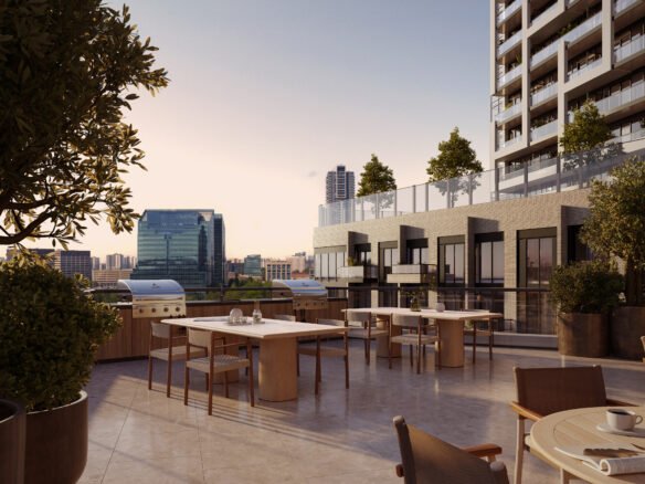 An outdoor rooftop dining area of a modern building, featuring several tables set for dining, potted plants, and overlooking a cityscape during sunset. Browse our Sg Homes for similar views in