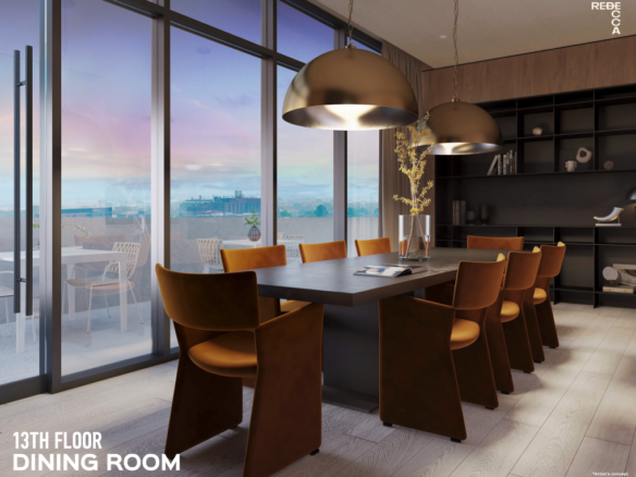 A modern dining room on the 13th floor of new homes in GTA features a long table with eight brown leather chairs, illuminated by two large pendant lights. Floor-to-ceiling windows offer a cityscape view. A built-in black shelving unit completes the contemporary design.