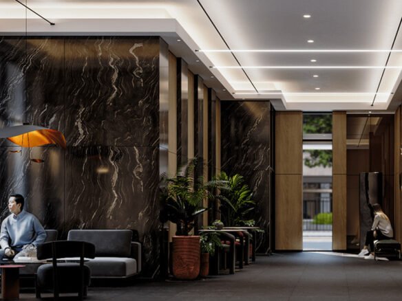 A modern lobby with marble walls and sleek lighting showcases the luxury of new homes. Two people are seated on separate sofas; one is reading, the other using a phone. Indoor plants adorn the space, while large windows offer a view of trees outside.
