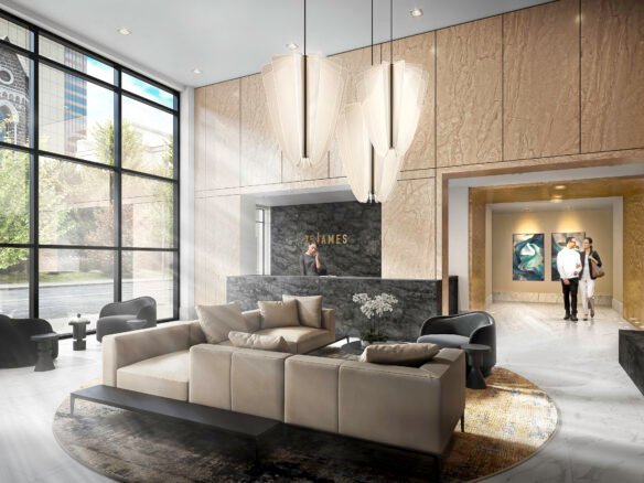A modern, spacious lobby with large windows allowing natural light to flood in. The area, reflective of the stylish interiors found in new condos in GTA, includes beige sofas arranged around a coffee table, elegant lighting fixtures, and a chic reception desk in the background. Two people walk toward an elevator area.