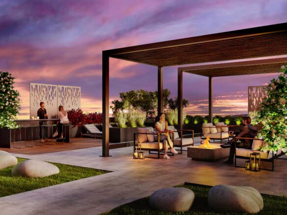 A stylish rooftop lounge at sunset features modern pergolas, comfortable seating, a fire pit, and lush greenery. People are socializing at a bar counter and sitting on armchairs, enjoying the elegantly landscaped space with ornamental rocks and illuminated panels—perfect for those considering new condos in GTA.
