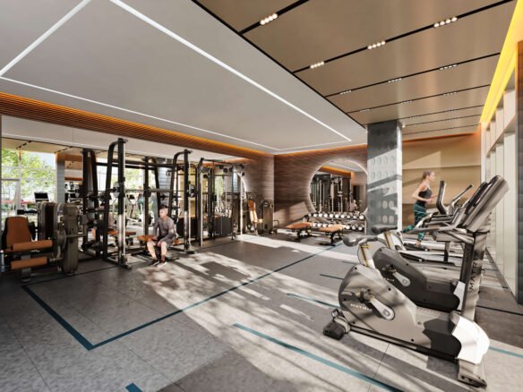 A modern gym with exercise machines, including treadmills, weightlifting equipment, and stationary bikes. A person uses the equipment as natural light streams in from large windows, creating a bright and inviting atmosphere—perfect for those living in new condos in Brampton nearby.