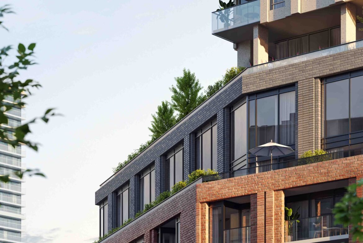 New condos in a modern residential building with brick, glass, and metal finishes featuring balconies with greenery, set against a backdrop of lush trees.