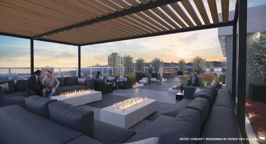 A rooftop lounge with modern seating and fire pits. People are sitting and conversing on dark-colored couches. The space is shaded by a pergola, and the background features a cityscape at sunset, reminiscent of new condos in GTA. Lush plants and contemporary design elements enhance the ambiance.