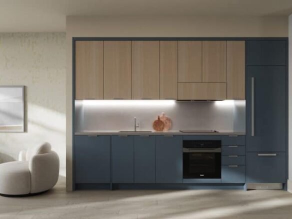 A modern kitchen with blue and wooden cabinets, stainless steel appliances, and a sink under bright task lighting in new condos.