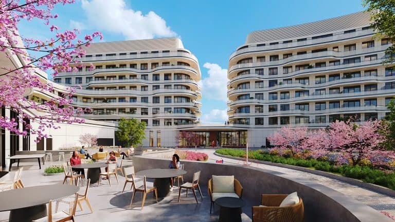 A digital rendering of modern courtyard with curved residential buildings showcases new condos and SG Homes. People sit at tables under blossoming pink cherry trees, enjoying the sunny outdoor setting.