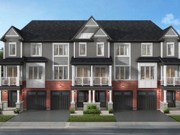 A row of three modern townhouses with gray siding and red brick exteriors, featuring large windows and balconies. Each house has an attached garage and neatly landscaped surroundings under a clear blue sky, showcasing the allure of new homes in GTA.