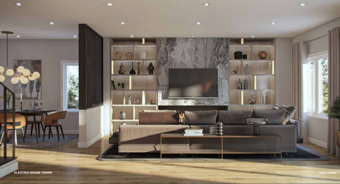 A modern living room with a large brown sectional sofa faces a wall-mounted TV. The wall showcases built-in shelves with decorative items. Bathed in natural light from windows and recessed ceiling lights, it exudes warmth. A dining area is visible to the left, ideal for those considering new condos in GTA.