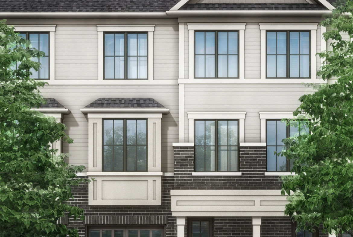 Image of a modern three-story townhouse with a gray and beige facade, large windows, and two garages. Flanked by vibrant green trees under a clear sky with scattered clouds, this residence epitomizes the charm of new homes in Brampton.
