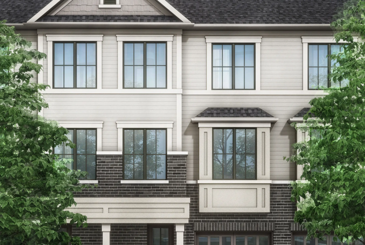 Discover a modern three-story townhouse with gray siding and dark brick accents, large windows, and two garage doors. Flanked by trees against a clear blue sky, it exemplifies the charm of new homes in Brampton.