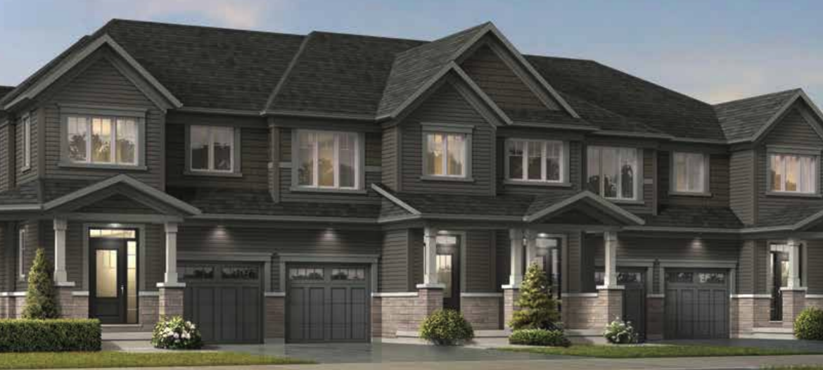 A row of new homes in Brampton features modern townhouses with dark gray siding, multiple windows, and attached garages. These stylish residences are surrounded by small shrubs and a neatly maintained lawn.