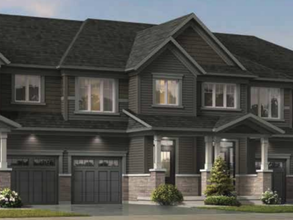 A row of new homes in Brampton features modern townhouses with dark gray siding, multiple windows, and attached garages. These stylish residences are surrounded by small shrubs and a neatly maintained lawn.
