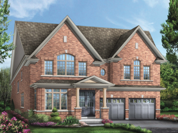 This large two-story brick house boasts a gabled roof, multiple windows, and two garage doors. The front yard is adorned with manicured shrubs and colorful flowers on a well-maintained lawn beneath the clear blue sky—a prime example of new homes in Brampton.