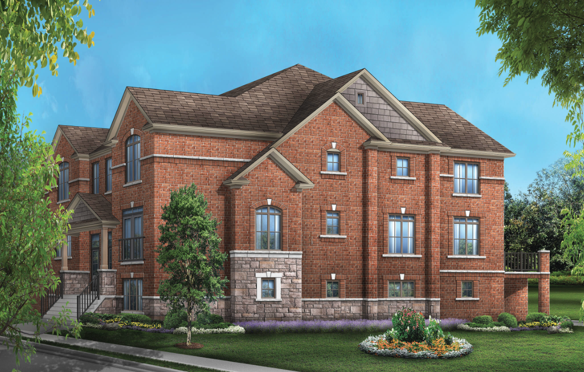 A spacious two-story brick house with multiple gables and windows stands against a blue sky. The front yard showcases well-maintained greenery and a flower bed, while trees frame the scene. Ideal for those exploring new homes, this property exudes charm and comfort.