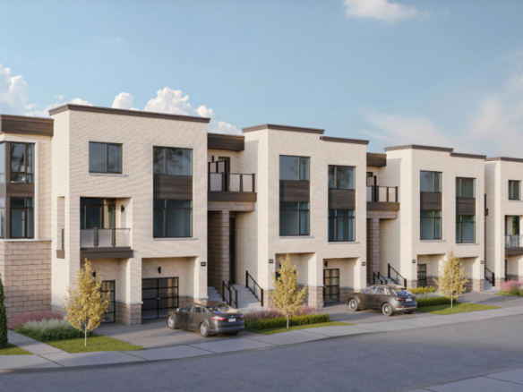 A row of modern, three-story townhouses with light brick exteriors, large windows, and small balconies sits in a beautifully landscaped area with trees and shrubs. Two cars are parked in the driveway under a partly cloudy sky. These are new homes in Brampton primed for elegance and comfort.
