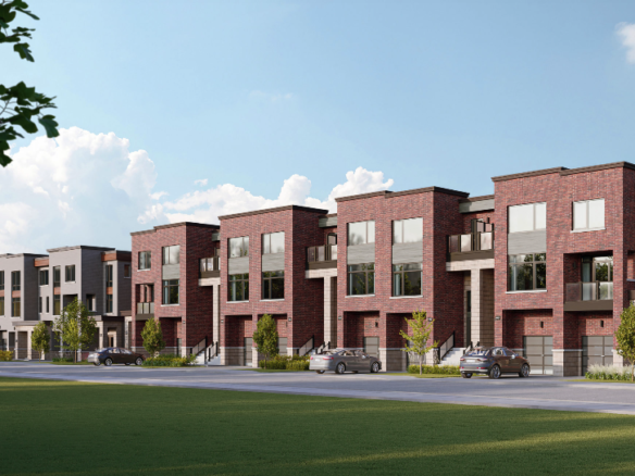 A row of modern townhouses with red brick facades and large windows under a blue sky showcases the charm of new condos in the GTA. Two cars are parked on the street in front, while small trees line the sidewalk. A grassy area enhances the foreground, offering a picturesque urban setting.