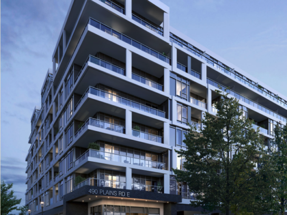 A modern multi-story apartment building at twilight features numerous balconies and large windows, showcasing new homes with contemporary design. The address "490 Plains Rd E" is visible on the facade, surrounded by trees and a bike rack. The sky is partly cloudy, adding to the serene streetscape.
