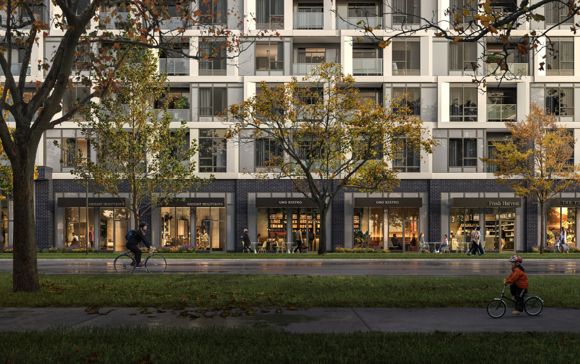 Discover new condos in the GTA within this modern apartment building, boasting retail shops on the ground floor. People stroll and ride bicycles along a tree-lined sidewalk, with autumn leaves scattered across the grass.