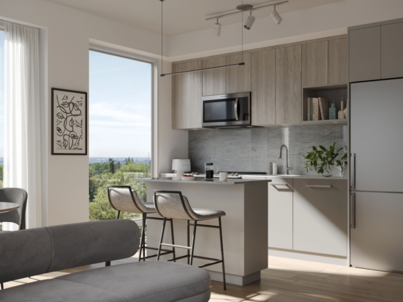 This modern kitchen interior features gray cabinets and a sleek island with barstools. A large window offers a view of greenery, while wall art and a potted plant add decorative touches. A micro-oven and stainless steel fridge complete the look, ideal for new homes with style-focused design.