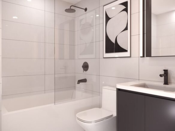 The Park Place VMC-inspired minimalist bathroom features a shower, bathtub, modern vanity with a black faucet, and toilet. Large gray tiles line the walls with a black and white abstract art piece above the toilet. The floor showcases sleek white tiles.