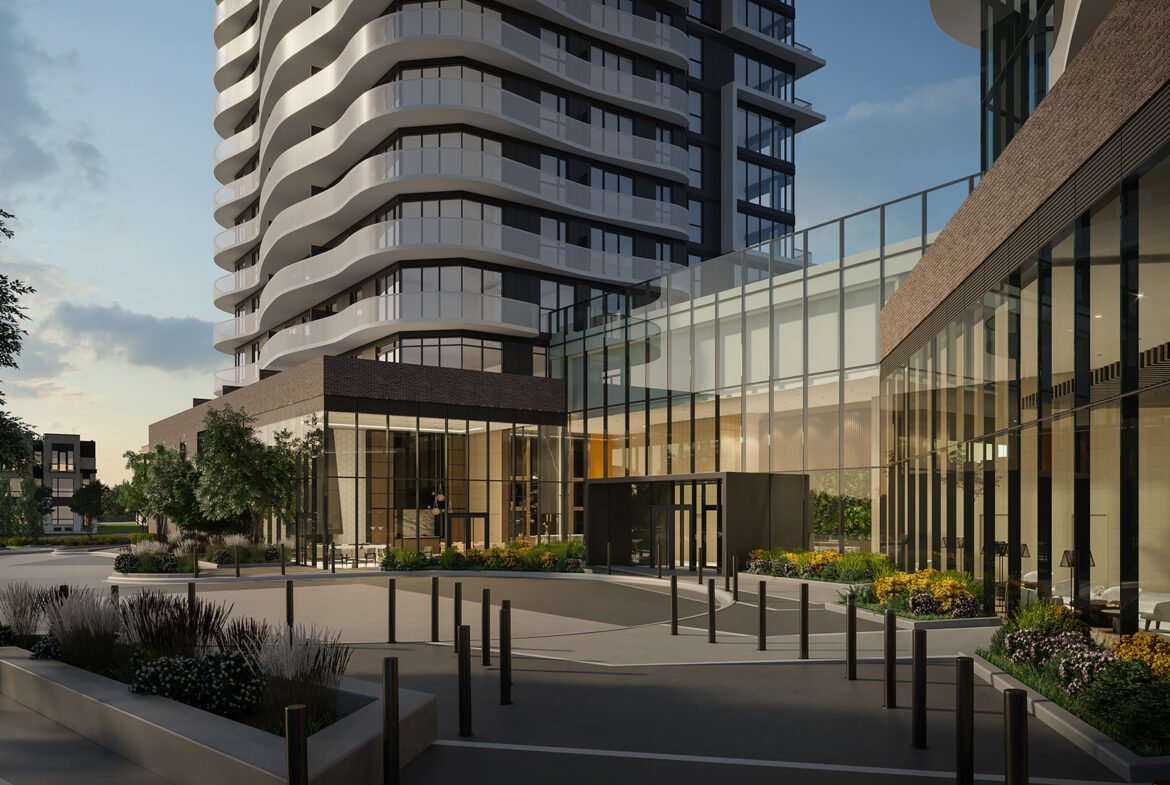 The modern urban development showcases a curved high-rise with glass and brick exteriors. In the foreground, landscaped gardens and a sleek entryway accentuate its allure against a clear sky, embodying contemporary architecture. Discover new condos in Brampton for an elevated lifestyle.