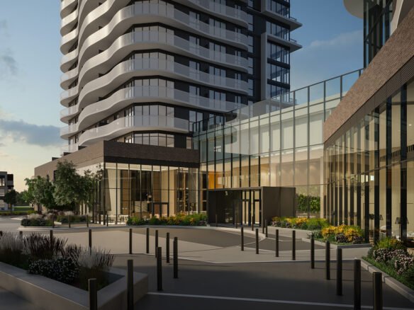 The modern urban development showcases a curved high-rise with glass and brick exteriors. In the foreground, landscaped gardens and a sleek entryway accentuate its allure against a clear sky, embodying contemporary architecture. Discover new condos in Brampton for an elevated lifestyle.