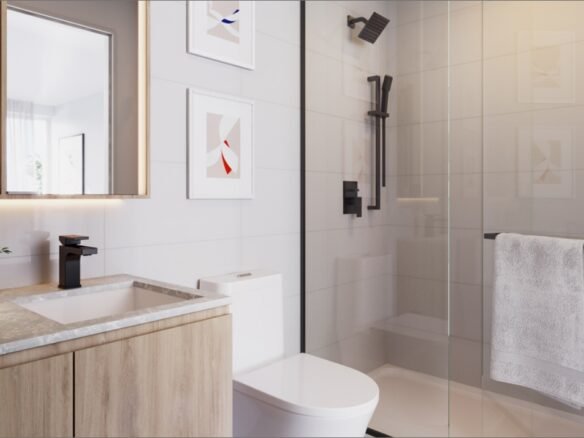 This modern bathroom in the new condos in GTA features a wooden vanity, white countertop, and sleek black fixtures. A large mirror and framed art adorn the wall, while a glass shower door holds a crisp white towel. Natural light floods through a window, enhancing the clean and minimalist design.