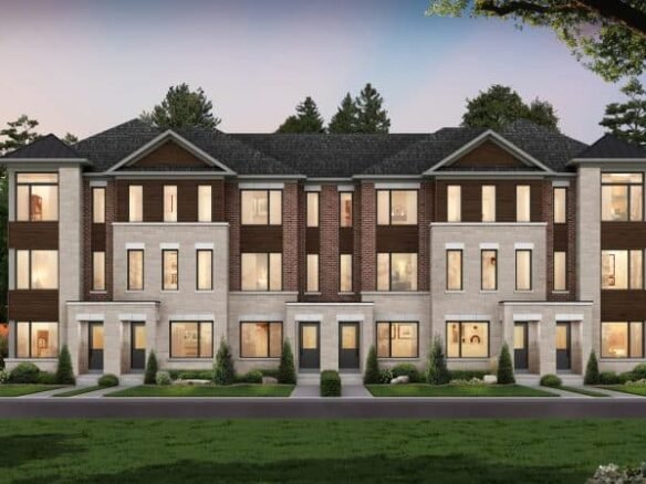A modern townhouse complex in South Barrie Towns features three connected units, large windows, a brick and stone facade, and landscaped greenery. The scene is beautifully set against a backdrop of trees at dusk.