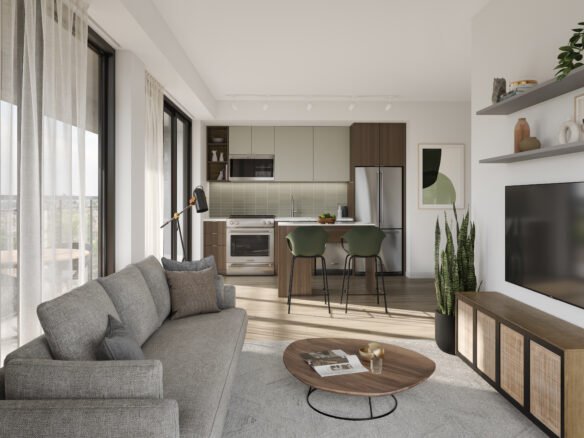 A modern living room and kitchen area with floor-to-ceiling windows in one of Toronto's new homes. It features a gray sofa, round wooden coffee table, wall-mounted TV, and a kitchen with green and brown cabinets. A plant and bar stools add accents to the space.