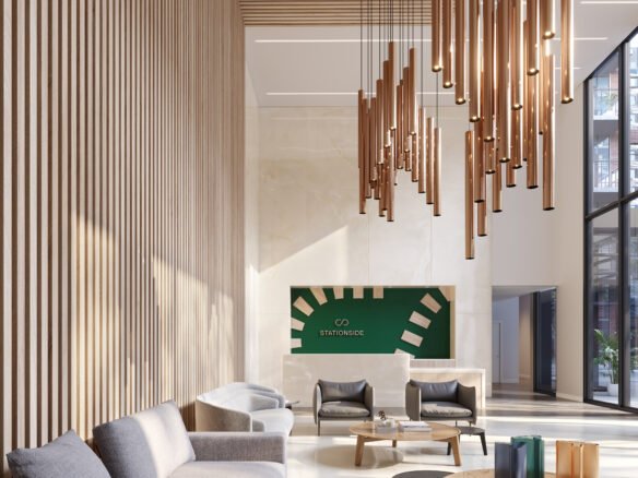 A modern lobby with wood paneling features a large hanging light fixture, gray couches, and a round wooden coffee table. A green sign with white graphics is on the far wall, and large windows flood the space with natural light—echoing the elegance of new condos in Brampton.