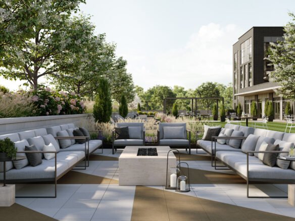 A modern outdoor patio features sleek gray sofas encircling a central rectangular stone fire pit. Adorned with potted plants and lanterns, this serene setting is enriched by the backdrop of trees and a contemporary building, ideal for new homes in Toronto.