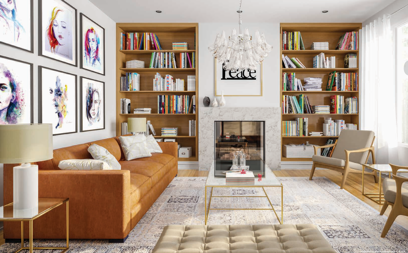 A stylish living room in one of the new homes features a brown leather sofa, two beige chairs, a glass coffee table, and a tufted ottoman. Bookshelves flank the fireplace, and framed artwork decorates the white walls. A chandelier hangs from the ceiling as large windows illuminate the space.