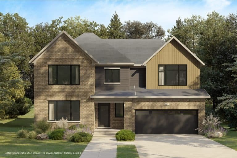 A two-story modern suburban house with a mix of brick and wood siding. It has large windows and a dark gray roof. The driveway leads to a double garage. The front yard, resembling a conservancy, features grass, shrubs, and small trees surrounded by wooded area in the background.